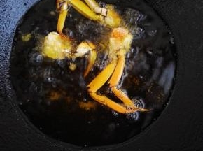 5、锅中倒入油250克，五成热时，将螃蟹放入炸熟，蟹盖要后放，在其他蟹身八成熟时放入即可。炸熟后捞出。