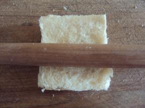 用擀面杖将每片吐司擀成薄片