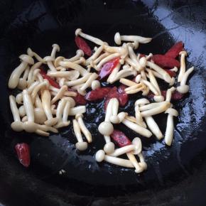 倒入腊肠，放精盐、蘑菇精，翻炒入味