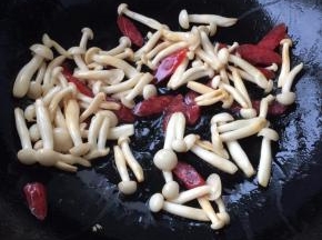 倒入腊肠，放精盐、蘑菇精，翻炒入味