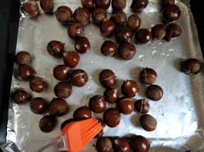 将糖水刷在板栗的开口处，再放入烤箱继续烤5分钟。