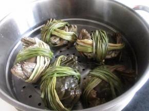 锅里烧开水，把大闸蟹用水冲洗几遍，带着苇草一起蒸。