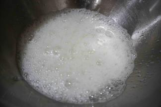 用电动打蛋器打至粗泡状态，加入1/3砂糖和1小撮盐和滴入几滴柠檬汁