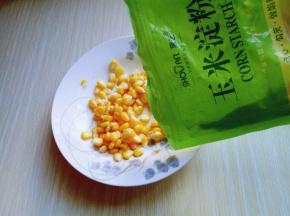 淋干水份的玉米粒加入容器中，倒入玉米淀粉。