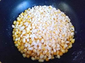 倒入挂满粉类的玉米粒，用勺子将玉米粒摊平整，接着转小火3-5分钟，使玉米粒都黏在一起成一块饼状。(煎的过程中不要动玉米粒，否则会散开。)