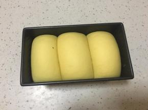 发到吐司盒9分满，取出在面团表面喷水