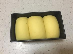 发到吐司盒9分满，取出在面团表面喷水