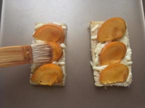 烘烤过程中将蜂蜜和清水调匀，时间到后取出烤盘，将蜂蜜水刷在柿子表面