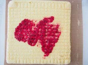 烤好的蛋糕晾至温热后抹上火龙果酱，卷起定型