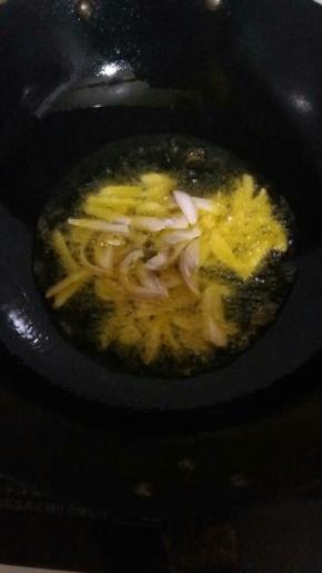 油温到7分时 ，放入葱姜蒜。放入肉翻炒。