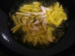 油温到7分时 ，放入葱姜蒜。放入肉翻炒。