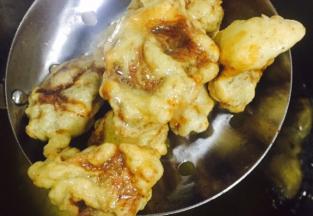 腌好的牛肉在面粉里裹一圈然后倒入热油中烹炸，第一次炸制金黄定型捞出，待牛肉全部炸好后倒入油锅复炸，直到触感变硬，颜色加深，捞出控油