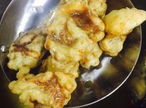腌好的牛肉在面粉里裹一圈然后倒入热油中烹炸，第一次炸制金黄定型捞出，待牛肉全部炸好后倒入油锅复炸，直到触感变硬，颜色加深，捞出控油