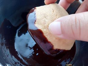 黑巧和淡奶油隔水加热融化均匀后，取一个脆脆杯把杯口边缘粘上巧克力。