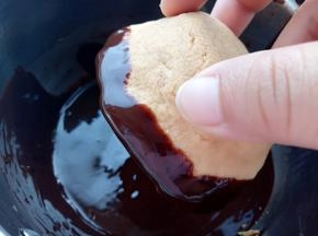 黑巧和淡奶油隔水加热融化均匀后，取一个脆脆杯把杯口边缘粘上巧克力。