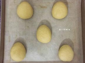 松弛好的面团再次排气，如需包馅料，在这步里包入馅料，我这里不包馅料，直接包成长椭圆形，稍微压扁，放在烤盘上