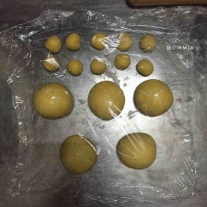 将发酵好的黄色面团排气，分出10份5克的面团，剩余的面团平均分为5份，揉圆并盖保鲜膜松弛10分钟