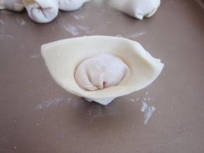 左边向右边涮清水的地方折起来，一个元宝形的馄饨就诞生了。