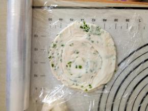 取一层保鲜膜将一个饼胚放在上面四周预留长一点膜，再将保鲜膜折回来在放上一个饼胚，依次做好所有的饼胚