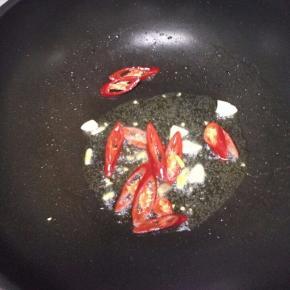 锅里倒入适量的油，把蒜与辣椒翻炒