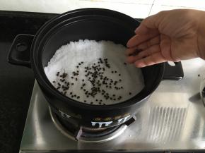 将粗盐倒入砂锅内，再放入花椒、八角和香叶；