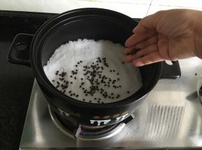 将粗盐倒入砂锅内，再放入花椒、八角和香叶；