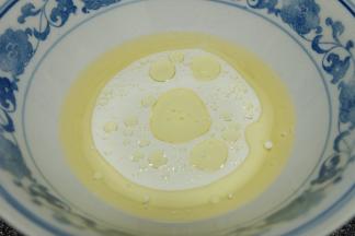 准备一个大碗，把玉米油和牛奶倒进大碗里；用手动打蛋器搅拌2分钟左右，使玉米油和牛奶充分乳化；