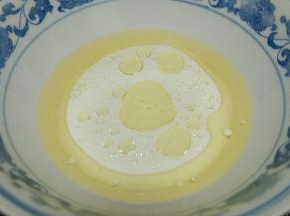 准备一个大碗，把玉米油和牛奶倒进大碗里；用手动打蛋器搅拌2分钟左右，使玉米油和牛奶充分乳化；