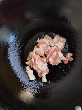 4、锅加热倒入食用油，放入五花肉煸炒。