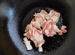 4、锅加热倒入食用油，放入五花肉煸炒。