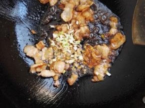 7、加入葱、姜碎，炒出香味。