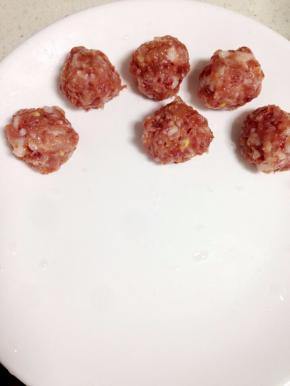 肉末腌制几分钟后，弄成丸子的形状放在盘子里。