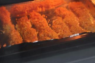 鸡柳都裹好面包糠后，铺上已经铺好锡纸的烤盘里，这时可以放入烤箱烤制啦！同样的温度上下火15分钟就可以了！