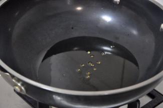 锅中烧油至7成热，倒入花椒。