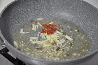 倒入少量泡椒炒香，因为小朋友不吃辣，所以放的比较少，自己吃可以多放一些。