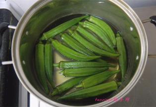在煮锅里放入水，水热后放入少许的食盐，倒入秋葵焯烫一下；