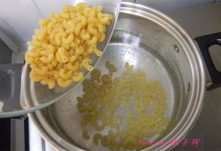 煮锅里的水冒小泡时倒入弯管意面，开始煮意面；