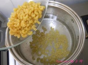 煮锅里的水冒小泡时倒入弯管意面，开始煮意面；
