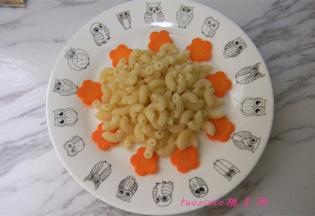 将切好的花形胡萝卜片铺在盘底做装饰（当然也可以吃了哈），捞出过凉的意面放入盘中；
