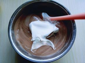 再取三分之一的蛋白霜加入蛋黄糊中，继续上面的手法，翻拌直至看不到蛋白霜。