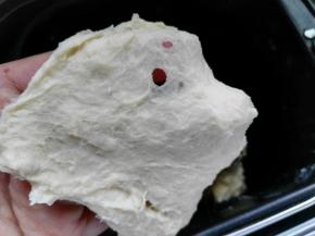 面包机桶内分别加入主料中除黄油以外的所有材料，揉15分钟左右，检查面团，已经可以拉出粗膜