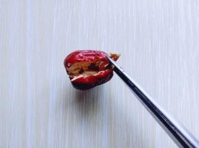 再将红枣核用剪刀的尖夹住用力拉下来，依次做完。