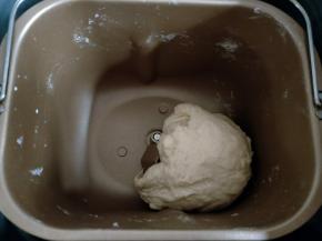 面包机先放牛奶和鸡蛋，对角放盐和糖，再放高粉，最后挖个洞放酵母。启动揉面程序15分钟。