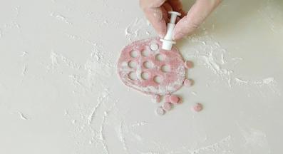 在和点白面团，面粉里加入适量红曲米粉，然后制出圆形面团。