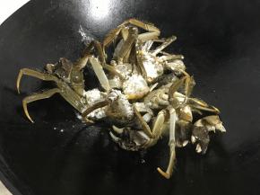 把裹了面粉的大闸蟹放油中炸。