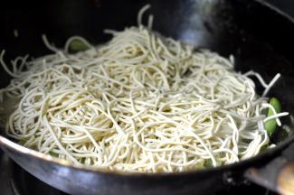 8、将切短的面条均匀的撒在豆角上面