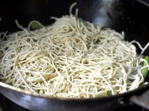 8、将切短的面条均匀的撒在豆角上面