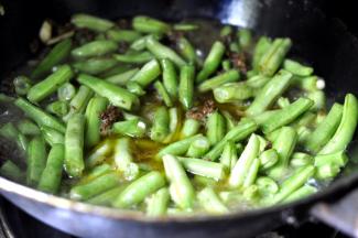 7、豆角炒至6成熟时，锅内倒入开水，淹没豆角