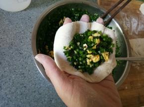 拿起一个面片舀上适量馅