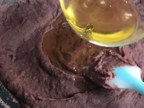 翻炒几分钟，水分流失很多，红豆沙体积缩小了一半，变浓厚，可以放油了。提前把两种油混合，分三次加油，每次都要等油和豆馅融合了再加下一次